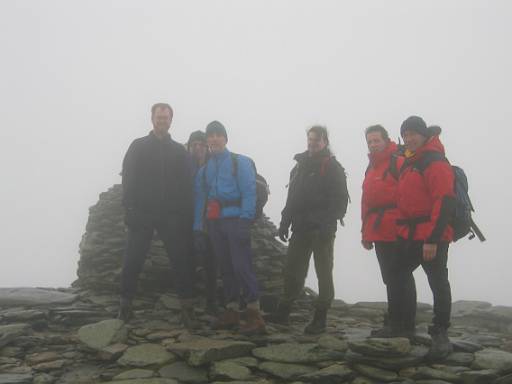 13_37-1.jpg - The summit of Coniston Old Man. Still windy and misty. Chris's hat has been blown clean off his head and into the mist.